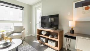 Landing Modern Apartment with Amazing Amenities (ID8359X76) في نيوبورت: غرفة معيشة مع تلفزيون بشاشة مسطحة على منصة