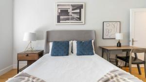 een slaapkamer met een bed met blauwe kussens en een bureau bij Landing Modern Apartment with Amazing Amenities (ID7294X83) in Somerville
