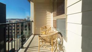 two chairs sitting on the balcony of a house at Landing Modern Apartment with Amazing Amenities (ID8359X76) in Newport