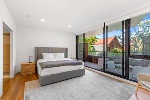 a bedroom with a bed and a large window at Fantastic 3-Bed Home by Melbourne Uni & Zoo in Melbourne