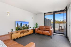 a living room with a television and a chair at Fantastic 3-Bed Home by Melbourne Uni & Zoo in Melbourne