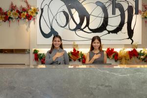 Due donne sono dietro un bancone con dei fiori di Cebu Grand Hotel a Cebu City
