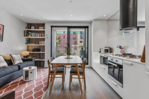 een keuken en een woonkamer met een tafel en stoelen bij Lovely & Quiet 2-Bed in the Heart of Carlton in Melbourne