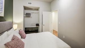 a bedroom with a white bed with pillows at Landing Modern Apartment with Amazing Amenities (ID8368X66) in Omaha