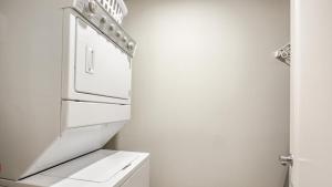 a white kitchen with a white stove top oven at Landing Modern Apartment with Amazing Amenities (ID8368X66) in Omaha
