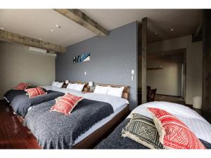 2 Einzelbetten in einem Schlafzimmer mit einer Wand in der Unterkunft Volcano - Vacation STAY 89674 in Kagoshima