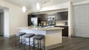 een keuken met een aanrecht en krukken op een eiland bij Landing Modern Apartment with Amazing Amenities (ID7650X68) in Dallas