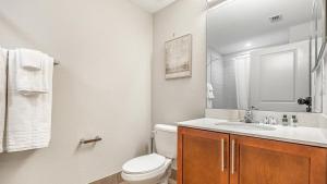 ein Badezimmer mit einem WC, einem Waschbecken und einem Spiegel in der Unterkunft Landing Modern Apartment with Amazing Amenities (ID8214X04) in Fort Myers