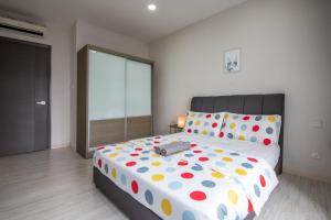 a bedroom with a large bed with polka dot sheets at A Lovely & Comfy Suite at Suasana Suites JB 11 in Johor Bahru