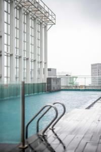 a swimming pool in a building with a metal railing at A Lovely & Comfy Suite at Suasana Suites JB 11 in Johor Bahru