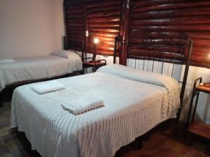 Un dormitorio con dos camas con toallas encima. en dulce claudina, en Mercedes