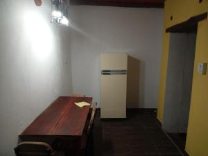 een kamer met een houten tafel en een koelkast bij dulce claudina in Mercedes