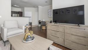 sala de estar con TV de pantalla plana grande en Landing Modern Apartment with Amazing Amenities (ID1337X194), en The Woodlands