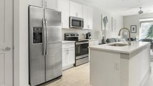 a kitchen with a stainless steel refrigerator and white cabinets at Landing Modern Apartment with Amazing Amenities (ID1374X218) in San Antonio