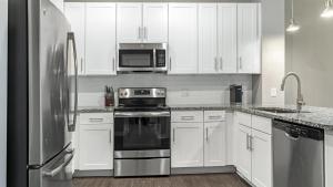 a kitchen with white cabinets and stainless steel appliances at Landing Modern Apartment with Amazing Amenities (ID1286X424) in Chapel Hill