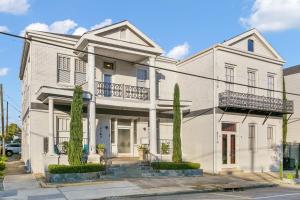 una casa bianca con degli alberi di fronte di Stunning 2-Bedroom Garden District Newly Renovated a New Orleans