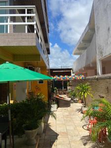 a patio with umbrellas and plants on a building at Pousada Residência dos Sonhos in Porto De Galinhas