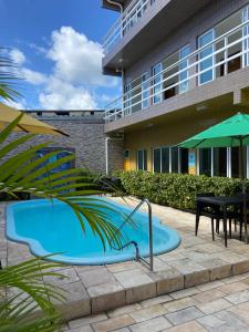 a pool in the courtyard of a building at Pousada Residência dos Sonhos in Porto De Galinhas