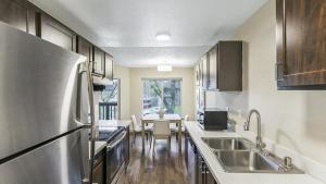 uma cozinha com um frigorífico de aço inoxidável e uma mesa em Landing Modern Apartment with Amazing Amenities (ID8880X29) em Federal Way