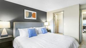 um quarto com uma grande cama branca com almofadas azuis em Landing Modern Apartment with Amazing Amenities (ID8880X29) em Federal Way