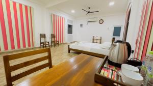 a living room with a bed and a table at Lagoon Step Transit Hotel in Katunayake