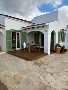 een wit huis met een patio met een tafel bij Apartamento nº 1 Cala Blanca in Cala Blanca