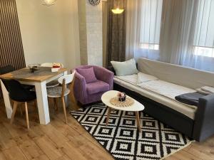 ein Wohnzimmer mit einem Sofa und einem Tisch in der Unterkunft Joy Apartment Burgas center private parking in Burgas City