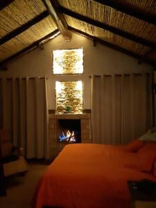 ein Schlafzimmer mit einem Bett und einem Kamin in der Unterkunft Linda mini casa campestre con Jacuzzi, chimenea... in Paipa