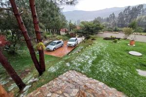 two cars parked in a yard with a frisbee at Linda mini casa campestre con Jacuzzi, chimenea... in Paipa