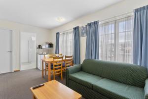 uma sala de estar com um sofá e uma mesa em Martin Cash Motel em Hobart