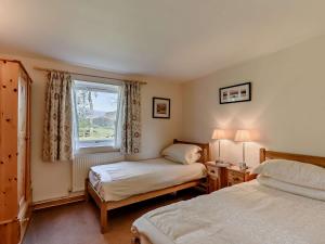 a bedroom with two beds and a window at 3 Bed in Newlands Valley SZ508 in Braithwaite