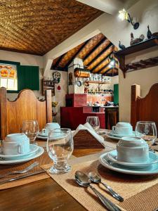 una mesa con platos y vasos encima en Pousada do Gentil, en Tiradentes