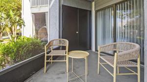 - deux chaises et une table sur une terrasse couverte dans l'établissement Landing Modern Apartment with Amazing Amenities (ID7958X11), à Lutz