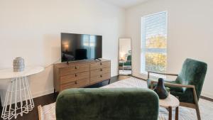 een woonkamer met een tv en een bank en een stoel bij Landing Modern Apartment with Amazing Amenities (ID8194X48) in Birmingham