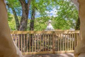 un porche con una valla de madera y árboles en Furnished Teepee/Glamping/Kayak Ramp/King Bed, en Stanton