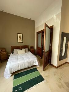 - une chambre avec un grand lit et un tapis vert dans l'établissement La Casona de Blanca, à Balcarce