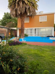 una casa con una palmera en el patio en Posada del Lago en Villa Carlos Paz
