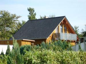 a small wooden house with a black roof at Holiday home Belvedere in Alt Schwerin