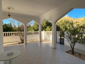 una veranda bianca con tavolo bianco e vista di Maison d'hôtes DAR DRISS a Matmata