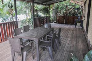 a wooden table and chairs on a wooden deck at Posada Las Palmeras in Bahía Solano
