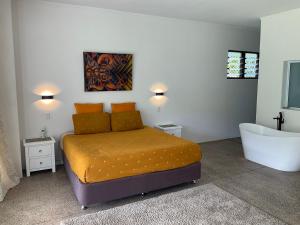 a bedroom with a bed and a bath tub at Temata Estate Rarotonga in Rarotonga