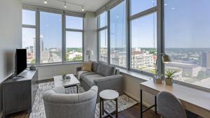 - un salon avec un canapé, des chaises et des fenêtres dans l'établissement Landing Modern Apartment with Amazing Amenities (ID8808X27), à Omaha