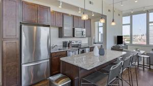 uma cozinha com um frigorífico de aço inoxidável e armários de madeira em Landing Modern Apartment with Amazing Amenities (ID8808X27) em Omaha