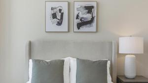 um quarto com uma cama com duas fotografias na parede em Landing Modern Apartment with Amazing Amenities (ID8808X27) em Omaha