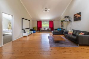 a living room with a couch and a table at The Palm Farm in Smiths Lake