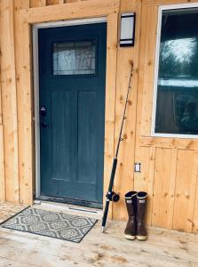 The Old Schoolhouse Lodge and Cabins في Coffman Cove: باب أخضر مع زوج من الأحذية أمام المنزل