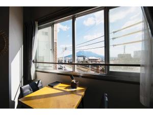 mesa y sillas en una habitación con ventana grande en Volcano - Vacation STAY 89669, en Kagoshima