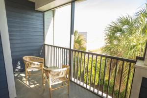 2 stoelen en een tafel op een balkon met uitzicht op het strand bij Landing Modern Apartment with Amazing Amenities (ID6446) in Brandon