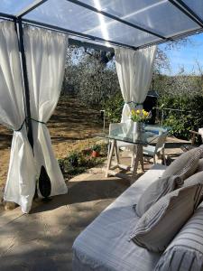 a patio with a tent and a table and a bed at mikipongTWO in Montepulciano