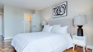 a white bedroom with a white bed and a lamp at Landing Modern Apartment with Amazing Amenities (ID2805X39) 